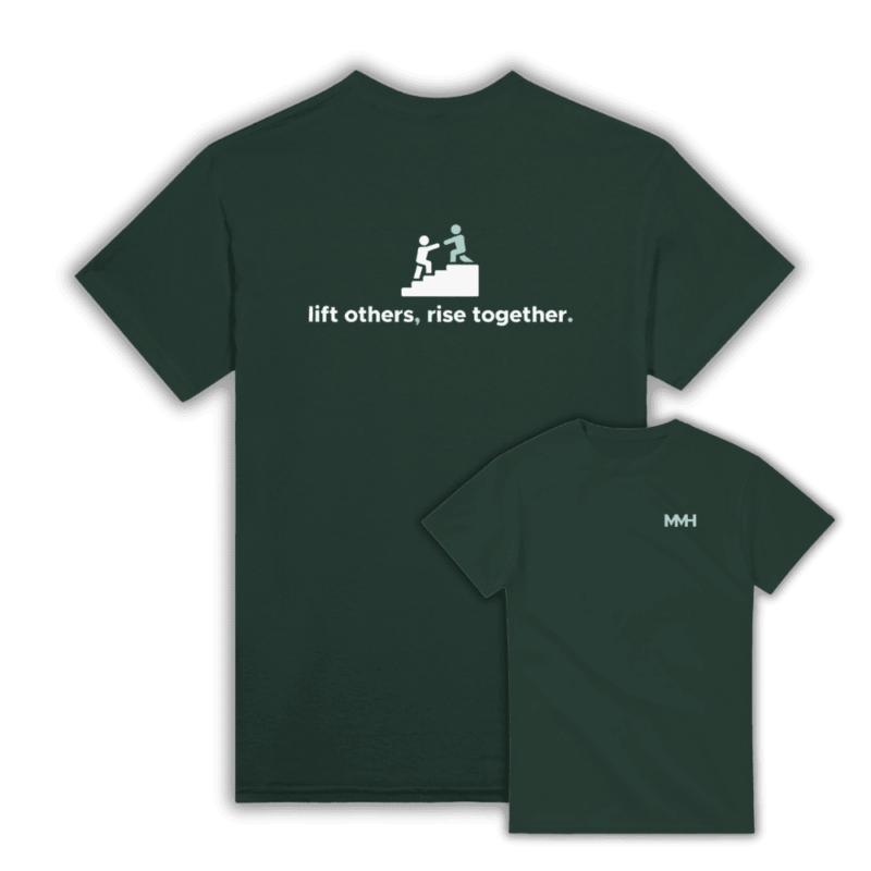 Forest green t-shirt with a back design showing one person helping another up stairs and the phrase “lift others, rise together.” Front logo includes MMH branding.