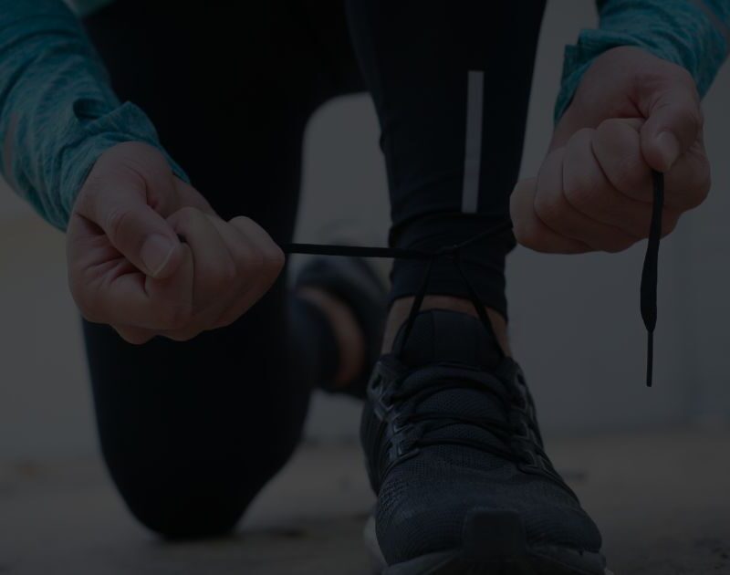 A runner tying shoelaces before a half marathon — symbolising Scott's journey to support men’s mental health through The Proper Blokes Club